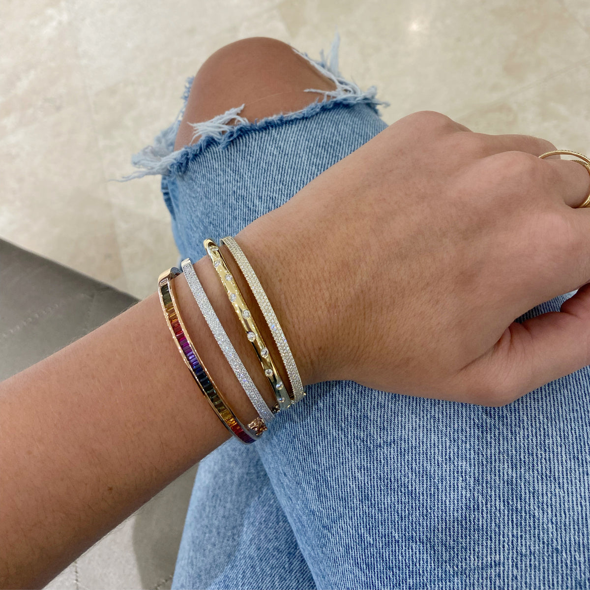 Female Model Wearing Diamond Dot Bangle  - 18K gold weighing 18.57 grams  - 11 round diamonds totaling 0.57 carats