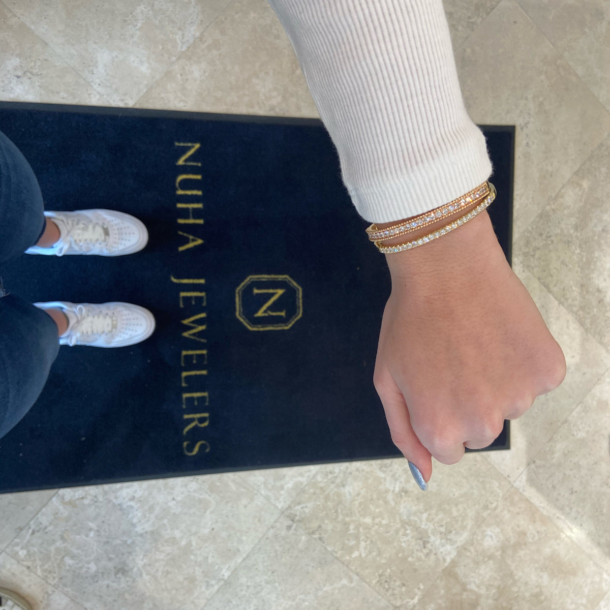 Female model wearing Diamond Wide Classic Bangle Bracelet -18k gold weighing 19.07 grams -25 round brilliant-cut pave-set diamonds totaling 2.02 carats.