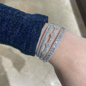 Female model wearing Baguette and Round Diamond Bangle Bracelet - 18K gold weighing 20.68 grams - 70 round diamonds weighing 1.12 carats - 51 slim baguettes weighing 0.98 carats