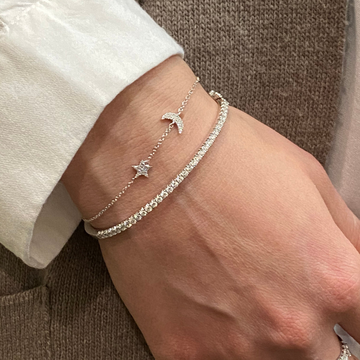 Female model wearing Diamond Star & Moon Bracelet - 14K yellow gold weighing 1.07 grams. - 29 Round diamonds totaling .06 carats.