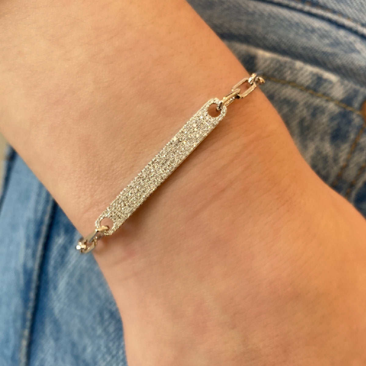 Female model wearing Diamond Bar Wide Link Bracelet - 14K gold weighing 5.64 grams - 157 round diamonds totaling 0.43 carats