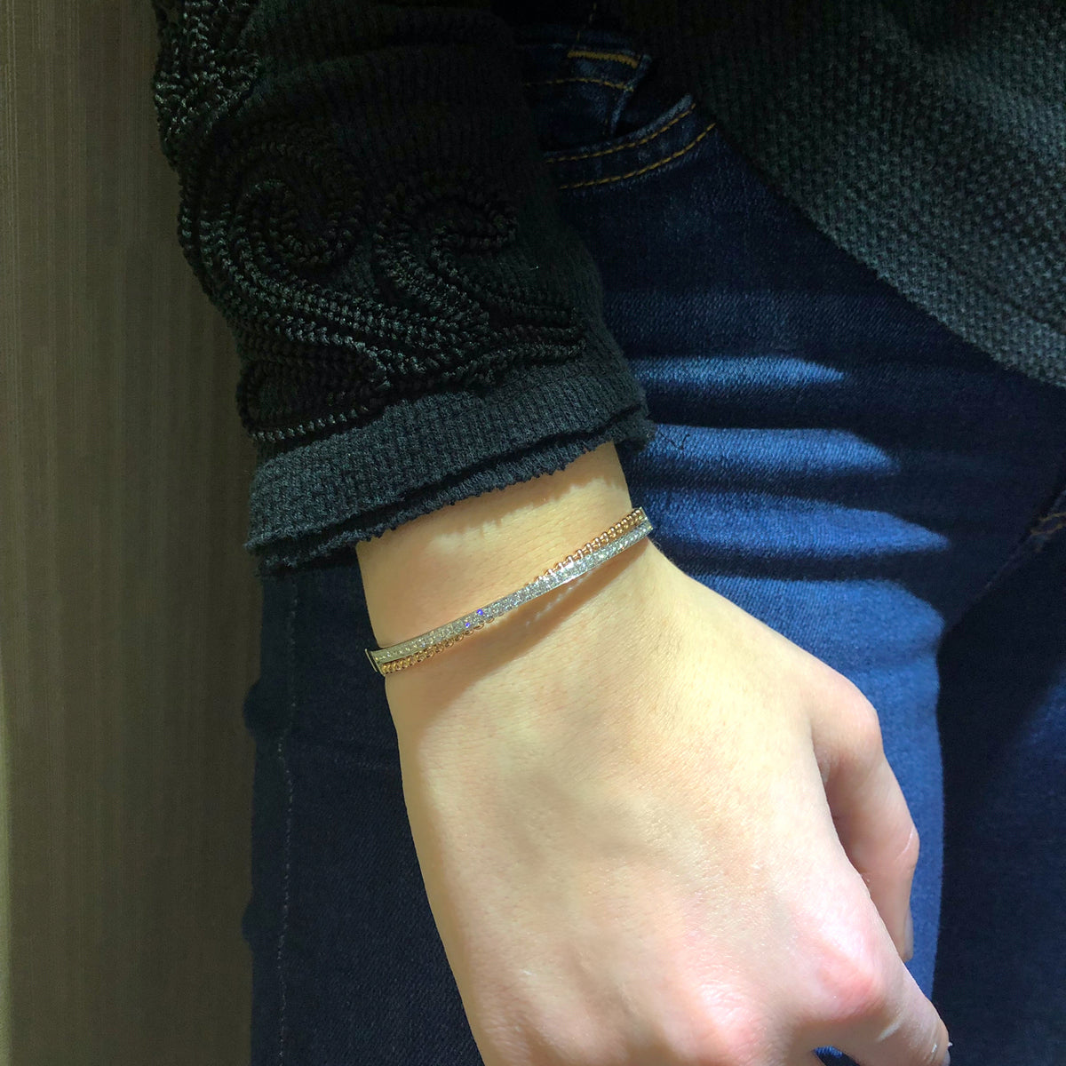 Female Model Wearing Diamond Two-Tone Crossover Bangle Bracelet  -14K gold weighing 15.82 grams  -39 round channel-set diamonds totaling .80 carats