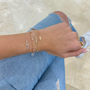 Female model wearing Diamond MAMA Curb Chain Bracelet - 14K gold weighing 3.13 grams - 46 round diamonds totaling 0.12 carats