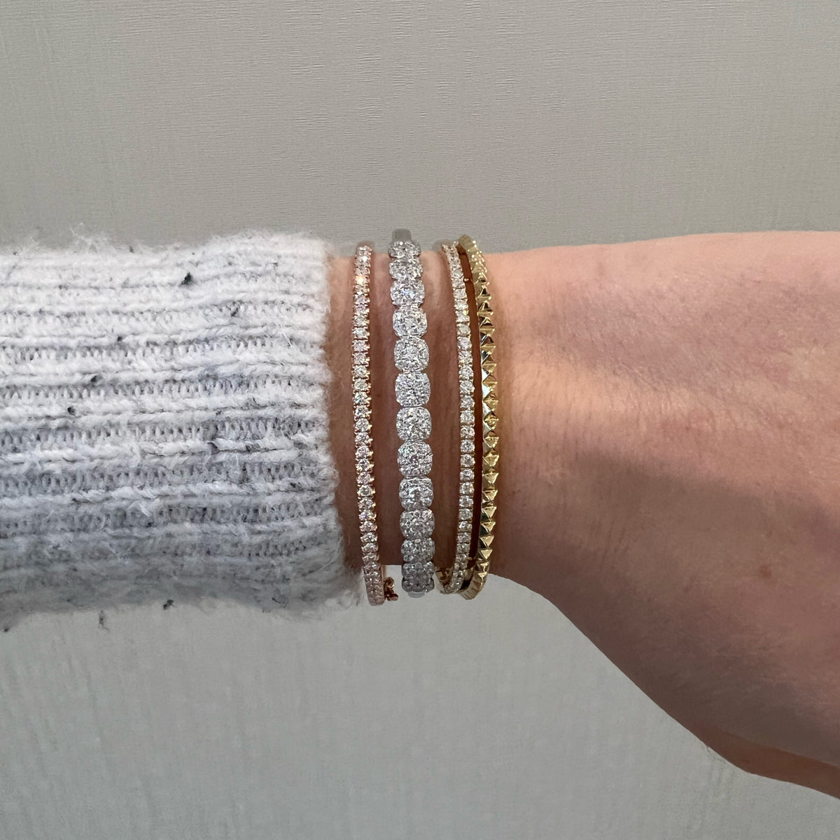 Female Model Wearing Solid 14K yellow gold weighing 16.06 grams featuring 35 round diamonds weighing 0.97 carats Diamond & Gold Pyramid Bangle | Nuha Jewelers