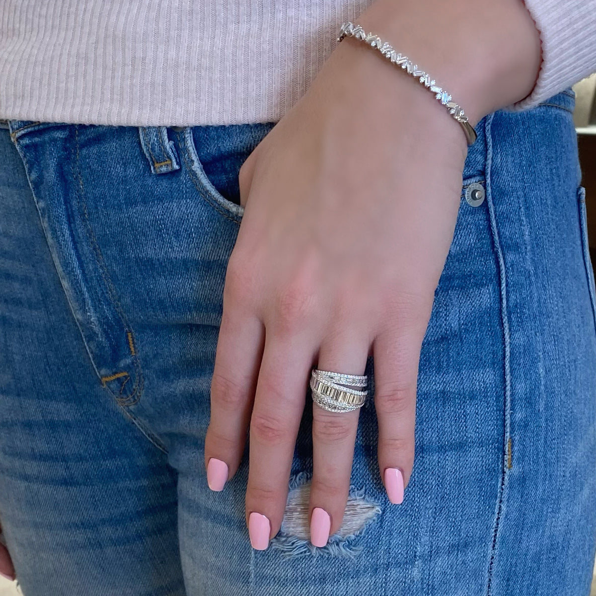 Female Model Wearing Baguette Diamond Crossover Ring  - 18K gold weighing 8.42 grams  - 128 round diamonds totaling 0.77 carats  - 40 slim baguettes totaling 1.98 carats