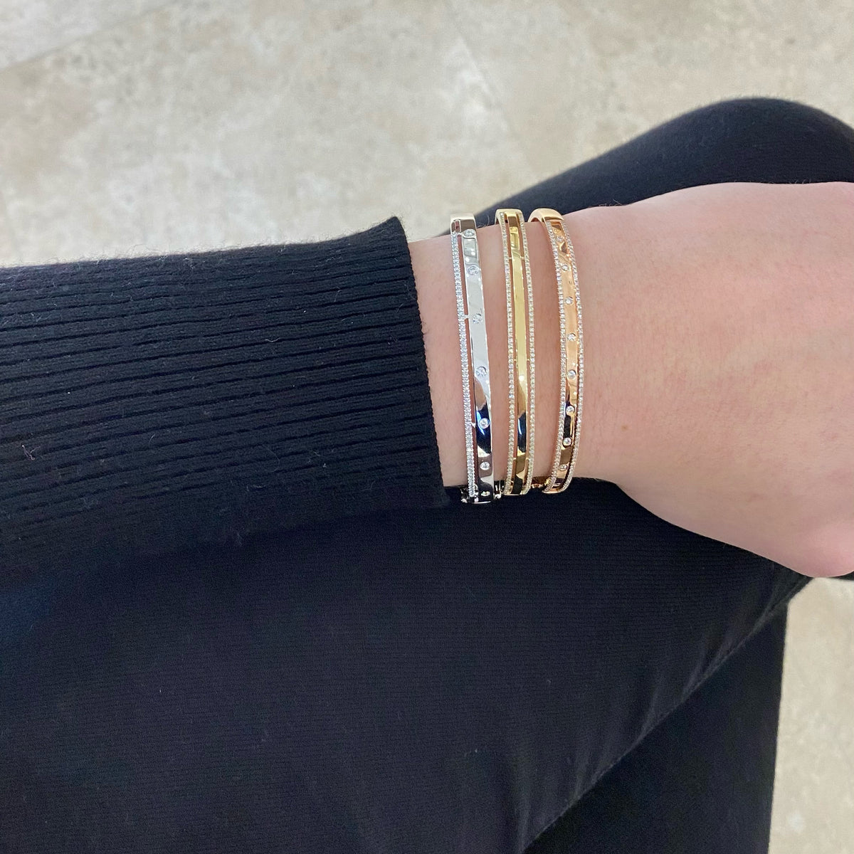 Female model wearing Diamond Double Bangle Bracelet - 14K gold weighing 15.2 grams - 86 round diamonds weighing 0.42 cts