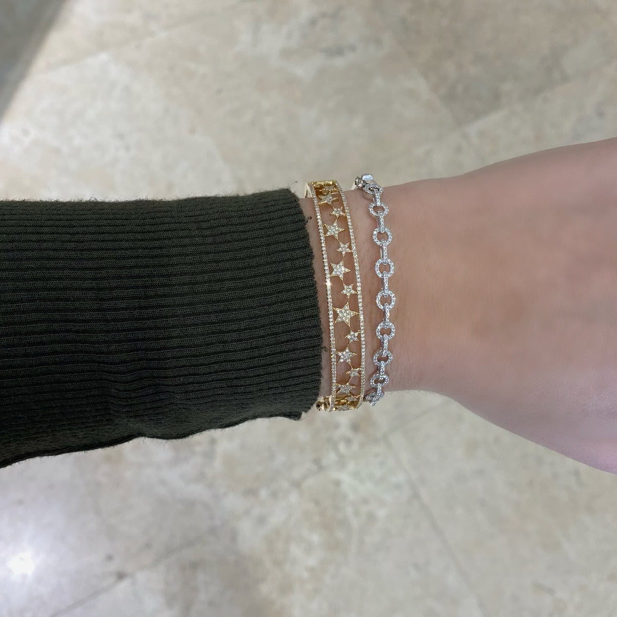 Female model wearing Diamond Star Cutout Bangle - 14K gold weighing 14.13 grams - 297 round diamonds totaling 0.90 carats