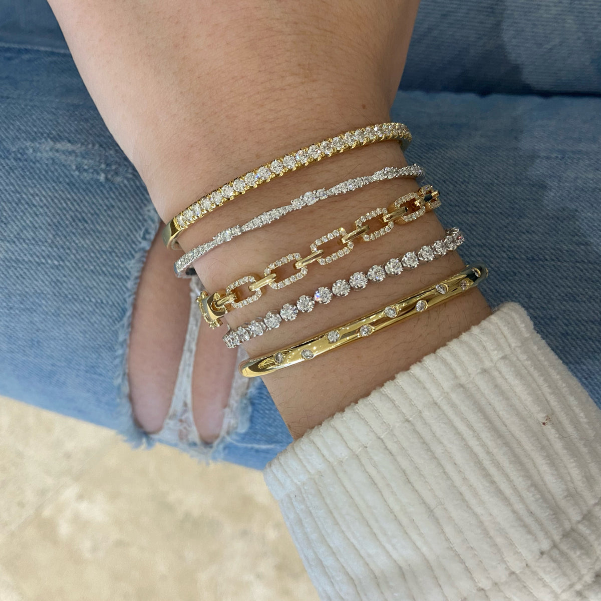 Female model wearing Diamond Elegance Bangle - 18K gold weighing 10.79 grams   - 41 round diamonds weighing 0.95 carats