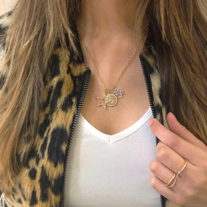 Female model wearing solid 14K yellow gold 1.10 gram weight with 38 round diamonds weighing 0.19 carats Paw Print Pendant | Nuha Jewelers
