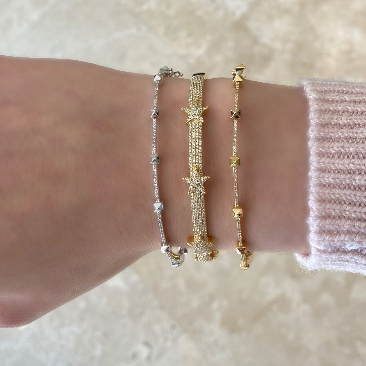 Female Model Wearing Diamond Tri-Star Bangle Bracelet  -14K gold weighing 13.48 grams  -301 round diamonds totaling 0.75 carats