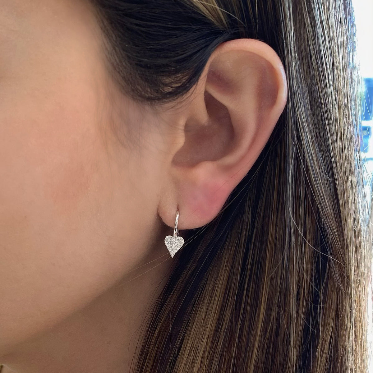 Female Model Wearing Pave Diamond Heart Lever-Back Earrings  - 14K gold weighing 1.88 grams  - 68 round diamonds totaling 0.20 carats