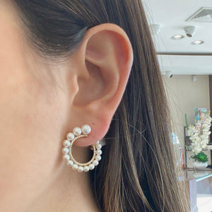 Female model wearing Pearl & Diamond front-facing hoop earrings - 14K gold weighing 3.48 grams  - 86 round diamonds totaling 0.27 carats  - 32 pearls