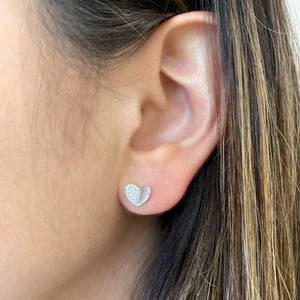 Female model wearing Diamond Half-Set Heart Stud Earrings - 14K gold weighing 1.42 grams - 44 round diamonds totaling 0.12 carats