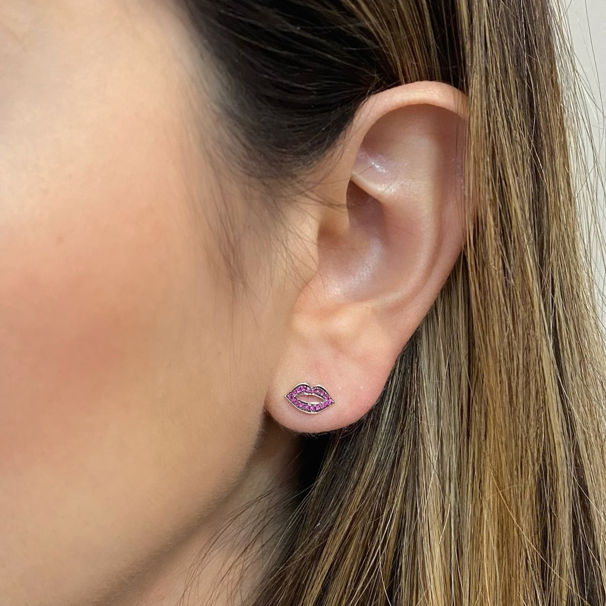 Female model wearing Diamond / Rubies Lips Stud Earrings - 14K gold weighing 1.08 grams - 36 round diamonds totaling 0.07 carats