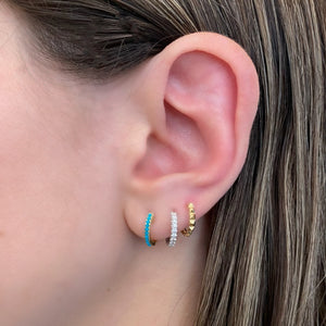 Female Model Wearing Turquoise Cabochon Huggie Earrings - 14K gold weighing 1.73 grams  - 22 turquoise cabochons totaling 0.23 carats