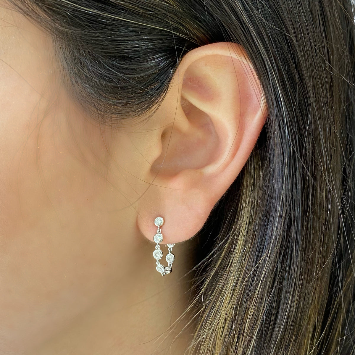 Female model wearing Diamond bezel front-back earrings- 14K gold weighing grams 1.84 grams  - 14 round diamonds totaling .37 carats