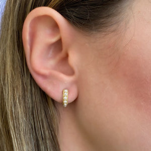 Female model wearing Pearl huggie earrings - 14K gold weighing 3.30 grams  - 12 pearls