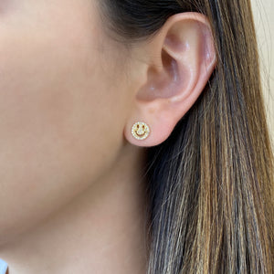 Female model wearing Diamond Smiley Face Stud Earrings - 14K gold weighting 1.55 grams. - 60 Round diamonds totaling .17 carat weight