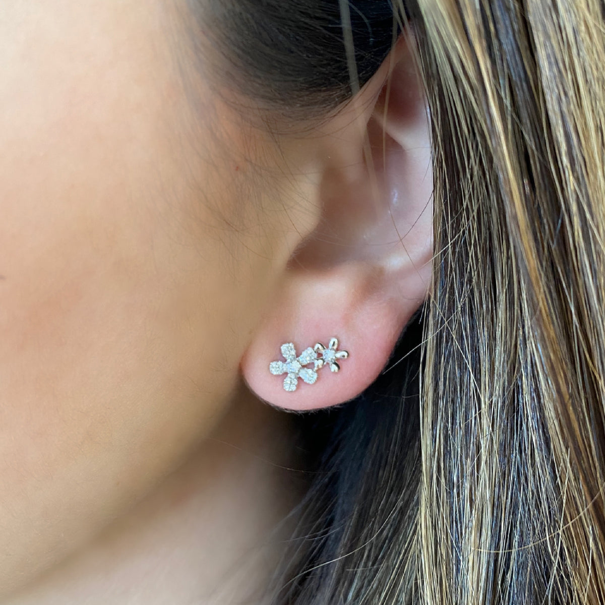 Female model wearing Diamond Double Flower Climbers - 14k gold weighing 1.92 grams - 54 round diamonds with 0.17 total carat weight