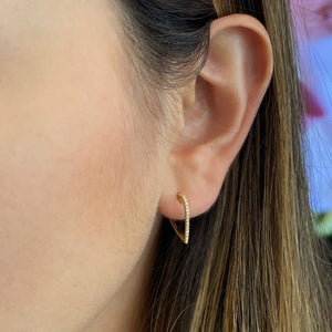 Female Model Wearing Diamond Open Heart Hoop Earrings - 14K gold weighing 1.49 grams  - 38 round diamonds totaling 0.11 carats