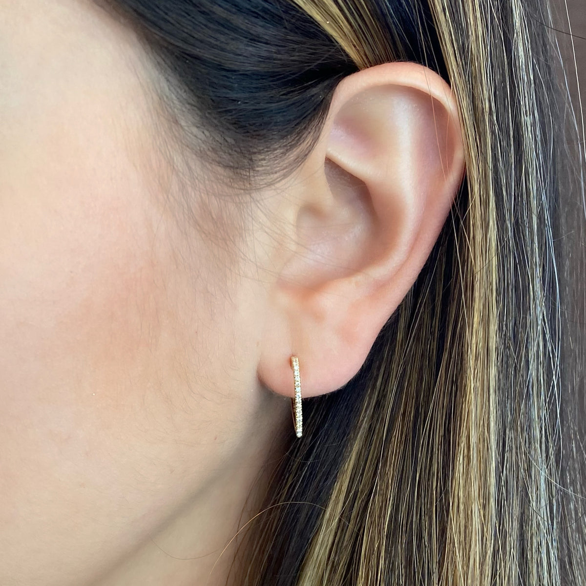 Female Model Wearing Diamond Open Heart Hoop Earrings - 14K gold weighing 1.49 grams  - 38 round diamonds totaling 0.11 carats