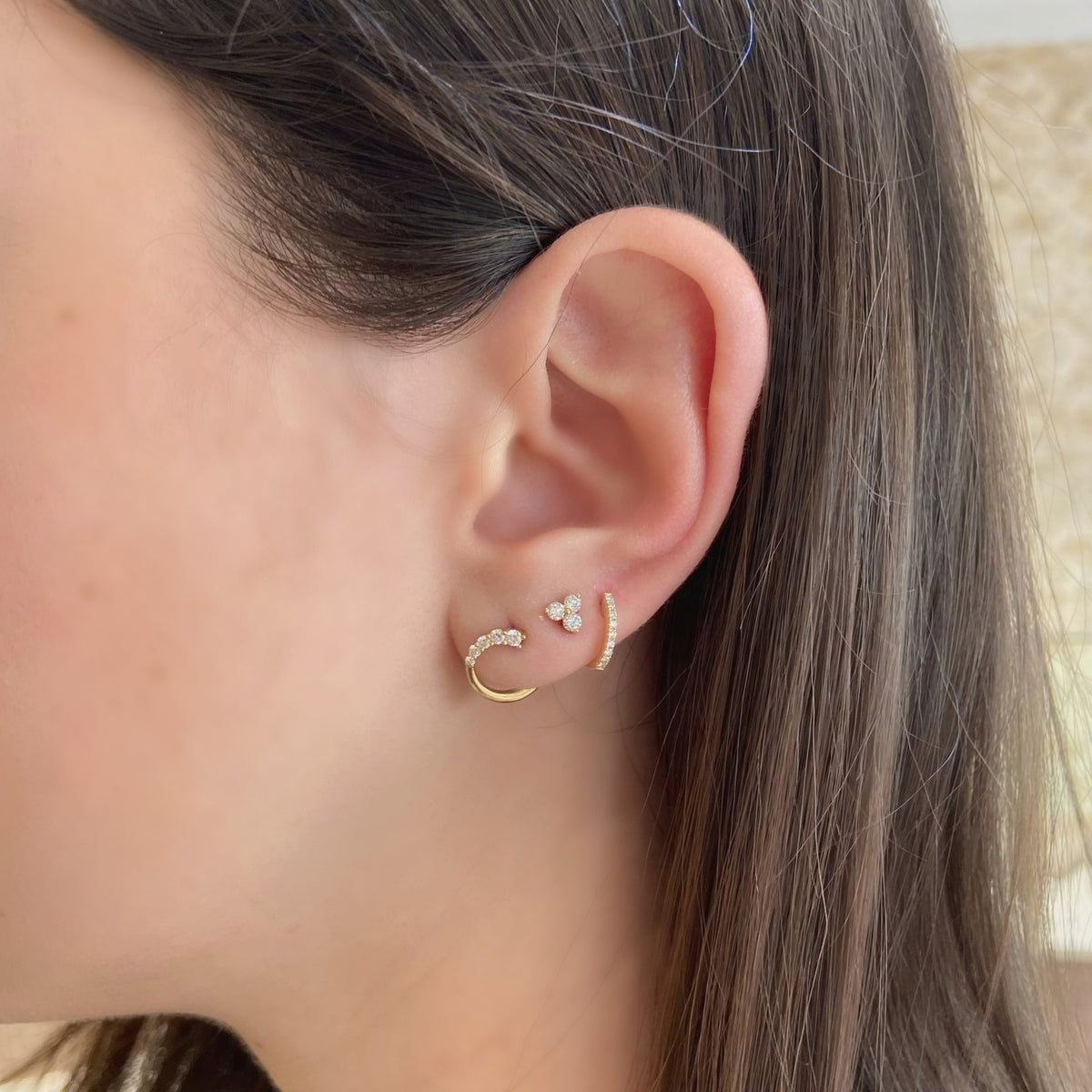 Female Model Wearing Diamond Petite Horseshoe Huggie Earrings - 14K gold weighing 1.15 grams  - 18 round diamonds totaling 0.13 carats