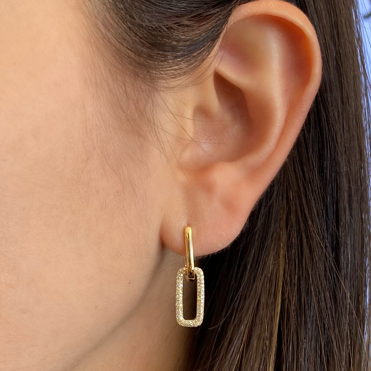 Female model wearing Diamond bold link earrings - 14K gold weighing 3.07 grams - 146 round diamonds totaling 0.34 carats