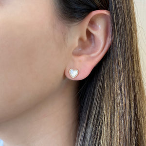 Female model wearing Mother of Pearl & Diamond Heart Stud Earrings - 14K yellow gold weighing 1.60 grams - 50 round diamonds totaling 0.10 carats.