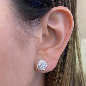 female model wearing Cushion-Shaped Diamond Halo Stud Earrings-18K gold weighing 2.46 grams -2 round diamonds weighing 0.32 carats -64 round diamonds weighing 0.70 carats