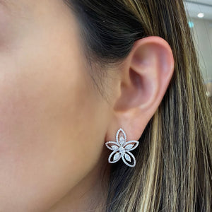 Female model wearing Diamond Oversized Flower Earrings - 18K white gold weighing 6.63 grams - 12 marquise-shaped diamonds totaling 1.64 carats - 170 round diamonds totaling 0.76 carats