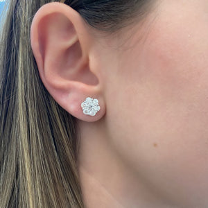 female model wearing Diamond cluster stud earrings - 18K gold weighing 2.86 grams  - 2 round diamonds totaling 0.52 carats  - 12 round diamonds totaling 1.76 carats