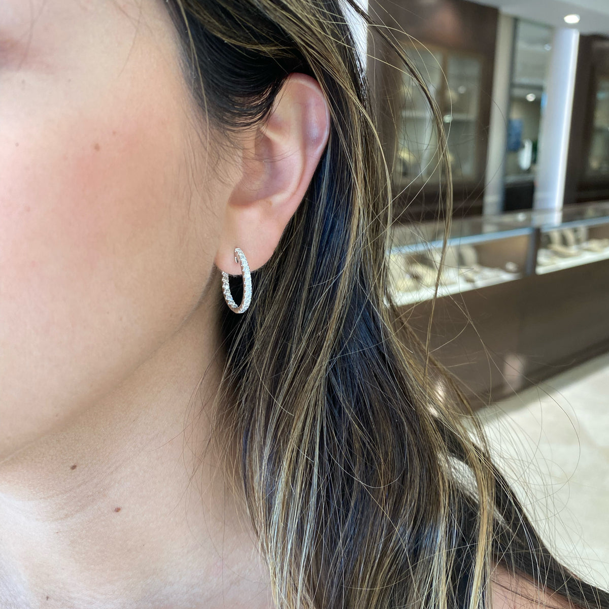 Female Model Wearing 18K gold weighing 4.49 grams featuring 44 round diamonds weighing 0.98 carats iamond Interior & Exterior Huggie Earrings | Nuha Jewelers