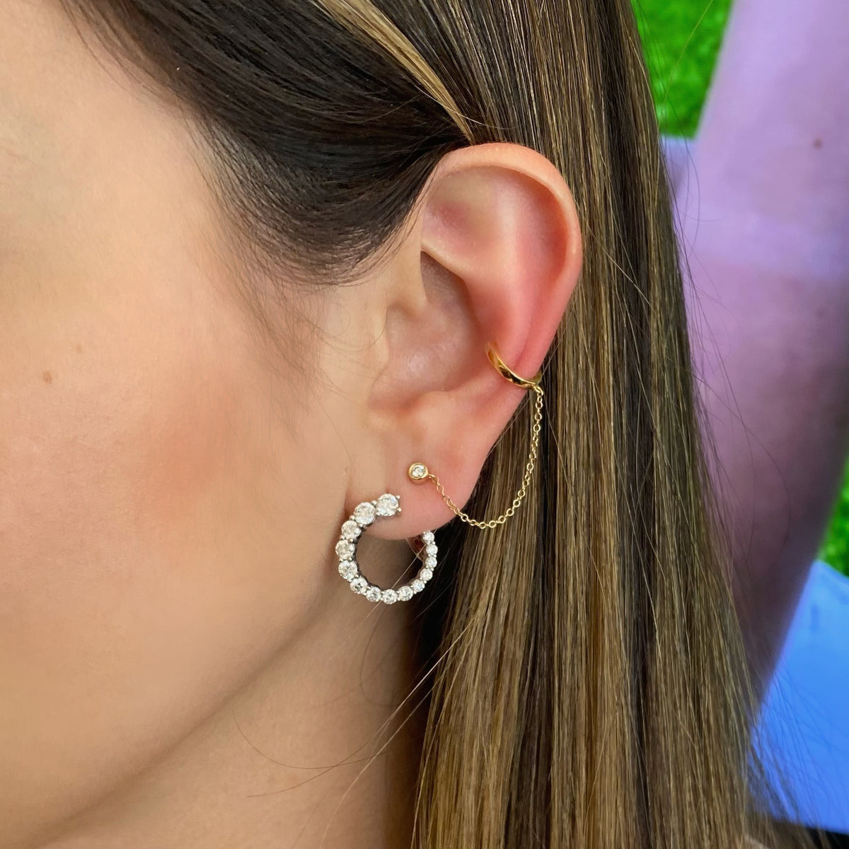 Female model wearing Ear Cuff with Chain and Bezel-Set Diamond Stud - 14K yellow gold weighing 1.14 grams - 1 round diamond totaling 0.05 ct.