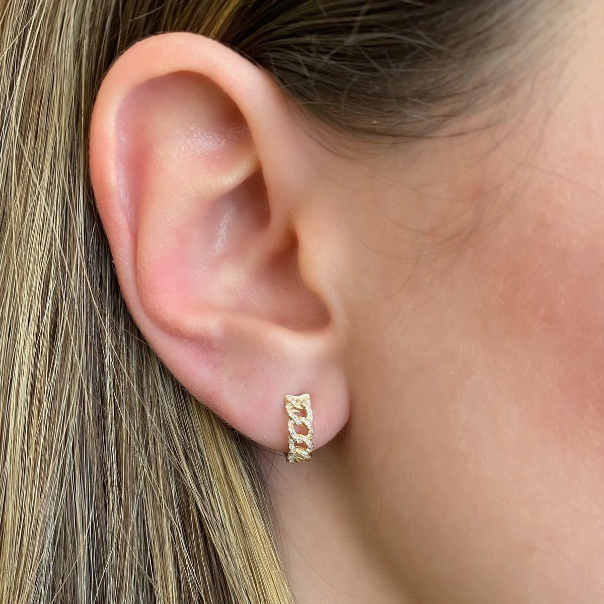 Female Model Wearing Diamond Curb Chain Huggie Earrings - 14K gold weighing 2.37 grams  - 80 round diamonds totaling 0.18 carats