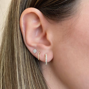 Female Model Wearing Diamond Slim Huggie Earrings - 18K gold weighing 1.05 grams  - 26 round diamonds totaling 0.06 carats