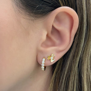 Female model wearing Prong-set diamond huggie earrings - 18K gold weighing 4.34 grams  - 10 round diamonds totaling 0.81 carats