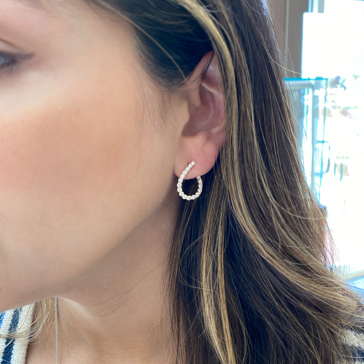 Female Model Wearing Diamond Open Teardrop Front-Facing Hoop Earrings - 18K gold weighing 3.01 grams  - 36 round diamonds weighing 1.34 carats