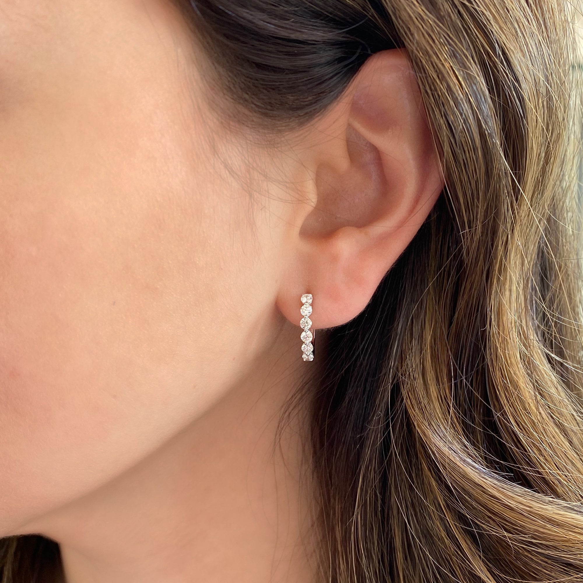 Diamond single-prong set huggie earrings  - 18K gold weighing 3.01 grams  - 12 round diamonds totaling 0.78 carats