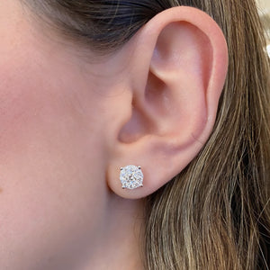 female model wearing 1.02 ct round diamond cluster earrings - 18K gold weighing 1.88 grams - 2 round diamonds totaling 0.51 carats - 18 round diamonds totaling 0.51 carats