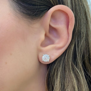 female model wearing 1.22 ct round diamond cluster earrings - 18K gold weighing 1.97 grams - 18 round diamonds totaling 0.60 carats - 2 round diamonds totaling 0.62 carats