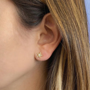 Female model wearing Round Diamond Star Stud Earrings - 14K gold weighing 1.00 grams - 52 round diamonds totaling 0.22 carats