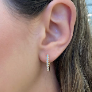 Female model wearing Diamond medium horseshoe huggie earrings - 18K gold weighing 2.90 grams  - 20 round diamonds totaling 0.50 carats