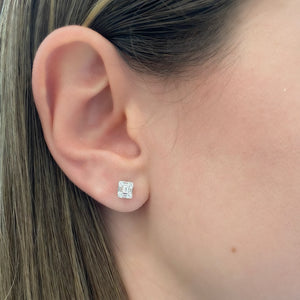 Female model wearing Illusion emerald-cut diamond small stud earrings - 18K gold weighing 1.28 grams - 10 slim baguettes totaling 0.37 carats - 8 round diamonds totaling 0.08 carats'