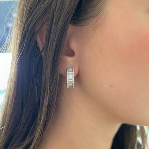 Female model wearing Baguette and Round Diamond Wide Huggie Earrings - 18K gold weighing 12.86 grams  - 60 round diamonds weighing 0.79 carats  - 30 slim baguettes weighing 1.91 carats