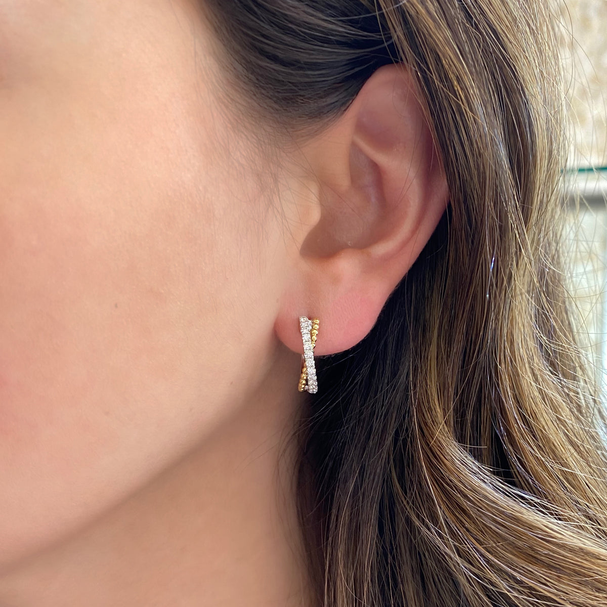 Female model wearing Half diamond half beaded gold huggie twist earrings -18k gold weighing 4.12 grams  -26 round diamonds weighing .41 carats