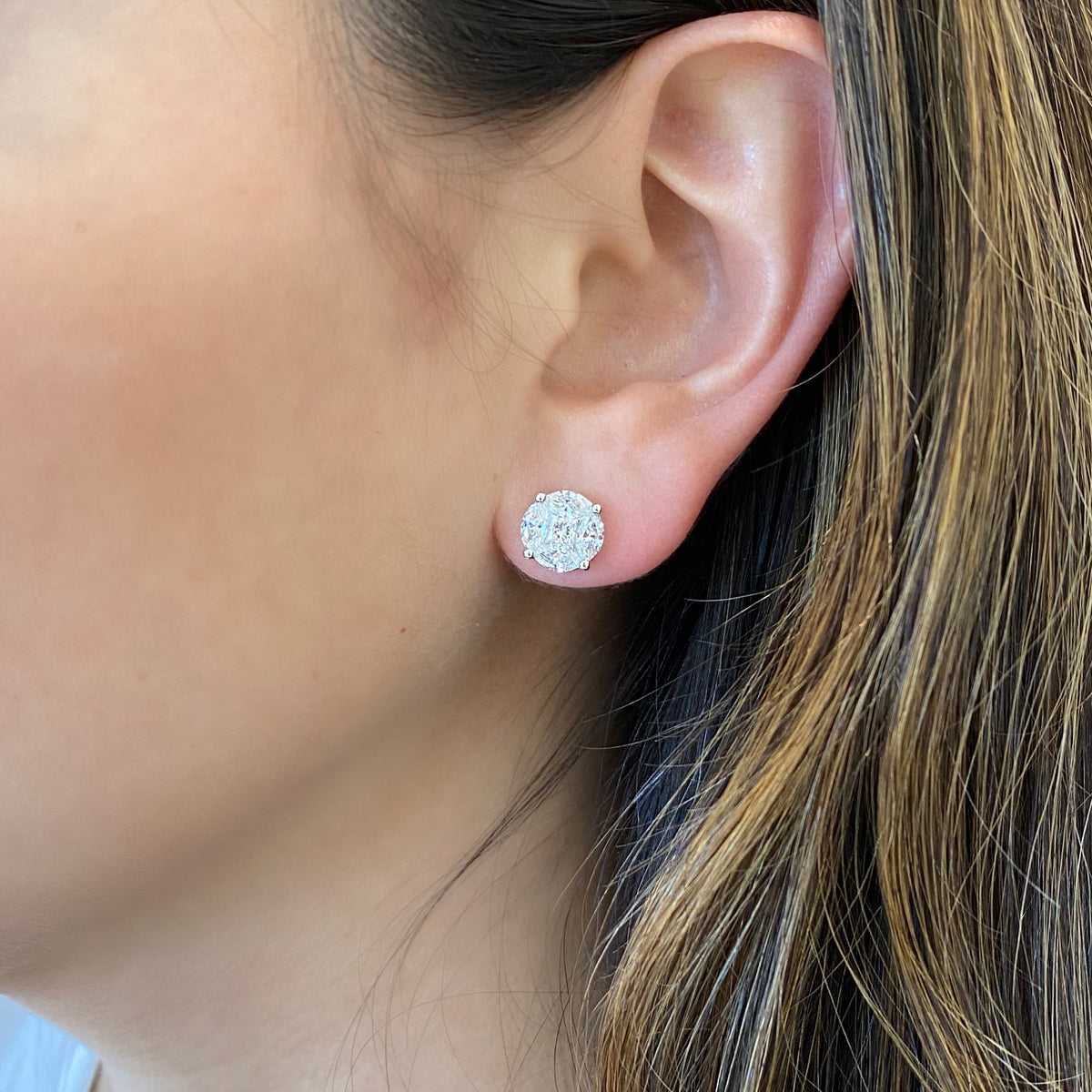 female model wearing mixed shape diamond stud earrings - 18K gold weighing 2.98 grams  - 8 marquise-shaped diamonds totaling 1.56 carats  - 2 princess-cut diamonds totaling 0.35 carats