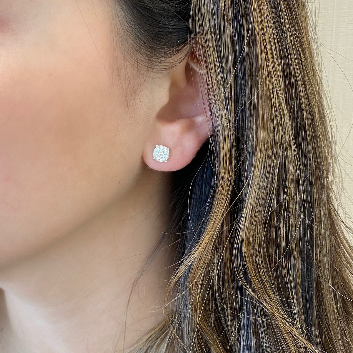 Female model wearing 0.56ct round diamond cluster earrings- 18k gold weighing 1.29 grams  - 18 round shared prong-set diamonds totaling .28 carats.  - 2 round shared prong-set diamonds totaling .28 carats.