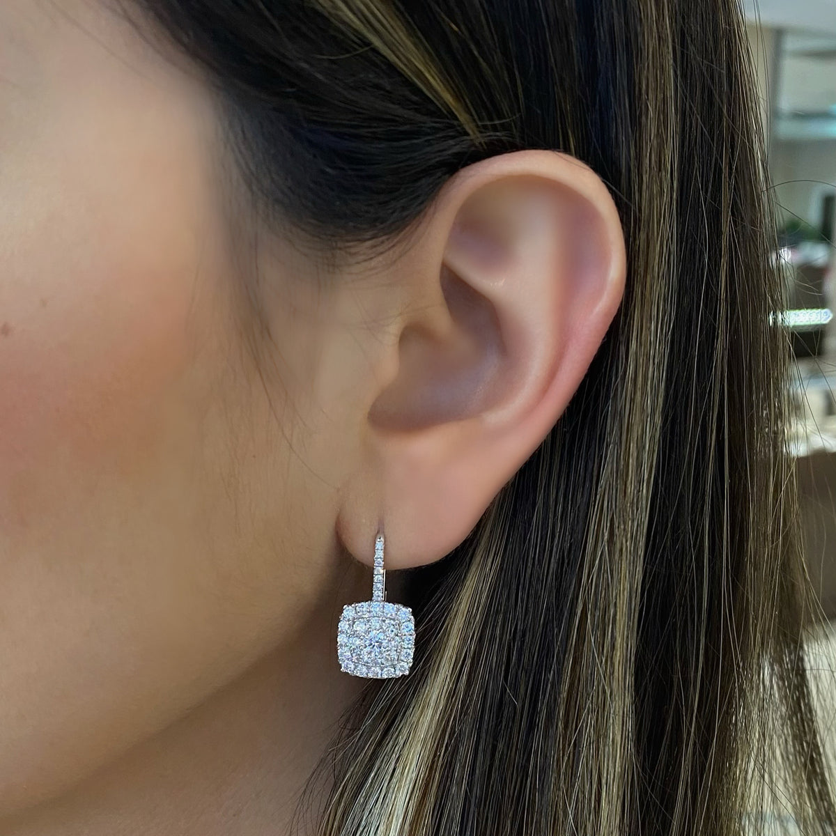 Female Model Wearing Diamond Cushion Lever-Back Earrings  - 18K gold weighing 4.75 grams  - 62 round diamonds totaling 1.77 carats  - 2 round diamonds totaling 0.47 carats