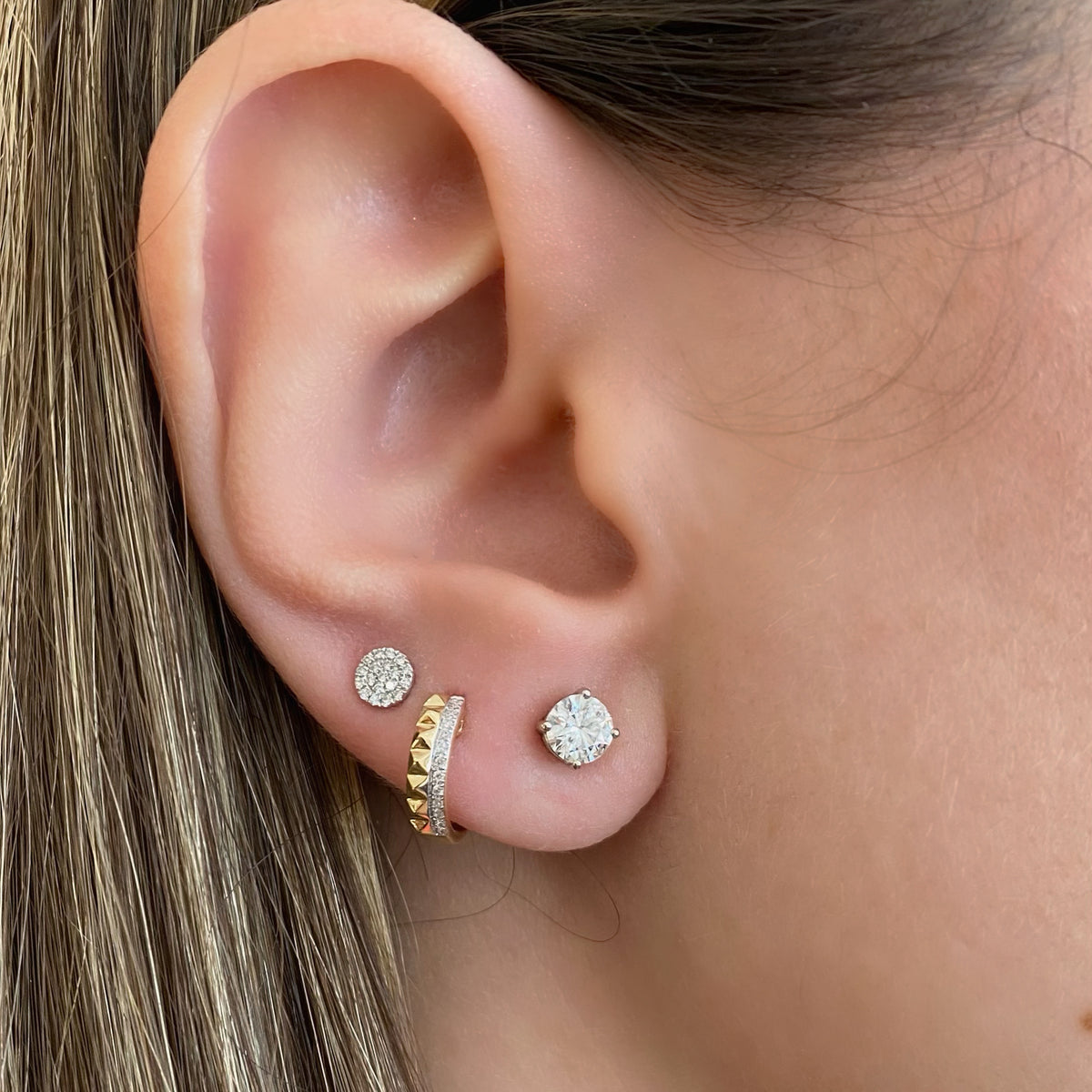 Female Model Wearing Half Diamond Half Gold Stud Huggie Earrings -14k gold weighing 1.80 grams  -24 round diamonds weighing .06 carats