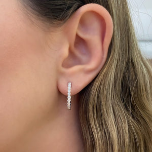 Female model wearing Diamond interior & exterior hoop earrings - 14K gold weighing 4.32 grams  - 58 round diamonds totaling 0.92 carats